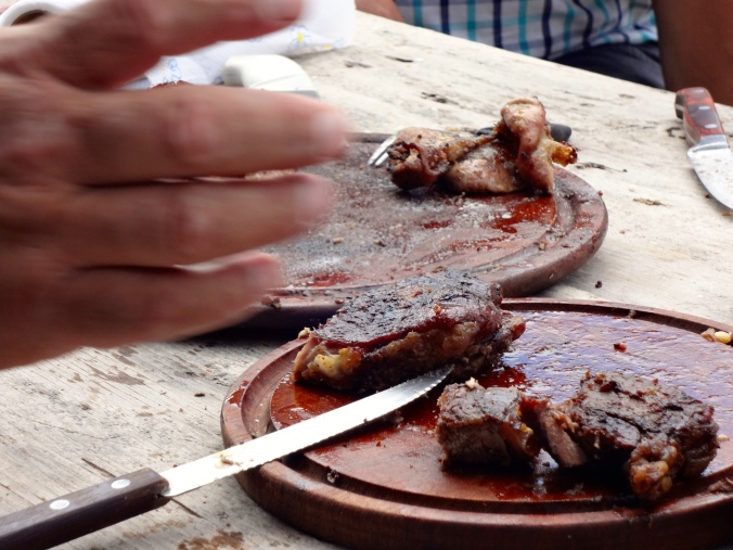 Not the best quality picture I have taken (with the lovely hand...) but here is some of the meat from an asado I attended a while ago. I believe the closer plate is steak and farther away is the chinchuline (intestines.) 